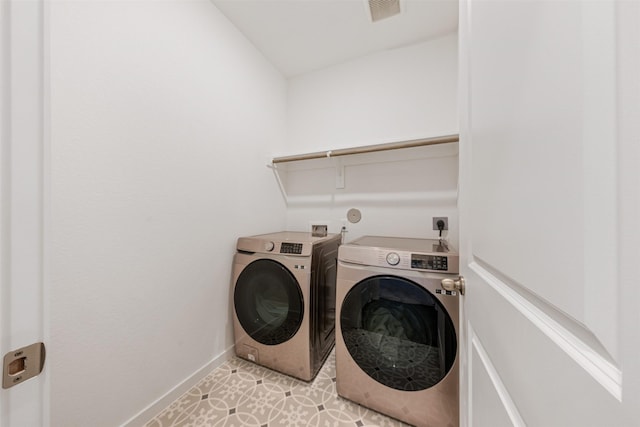 laundry room with visible vents, washing machine and dryer, light tile patterned flooring, laundry area, and baseboards