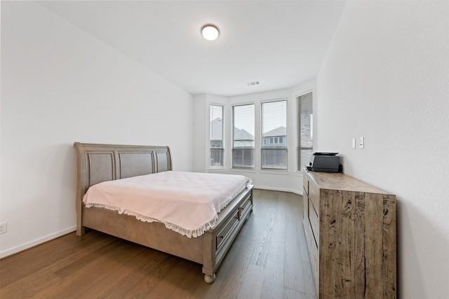 bedroom featuring baseboards, visible vents, and dark wood-type flooring