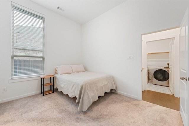 bedroom with washer / dryer, visible vents, vaulted ceiling, and carpet flooring