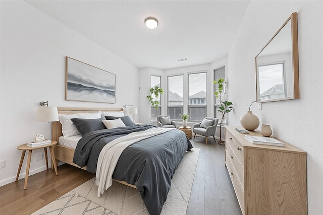 bedroom with light wood-style floors, baseboards, and visible vents