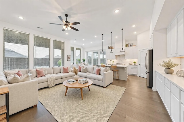 living room featuring ceiling fan, recessed lighting, visible vents, and light wood-style floors