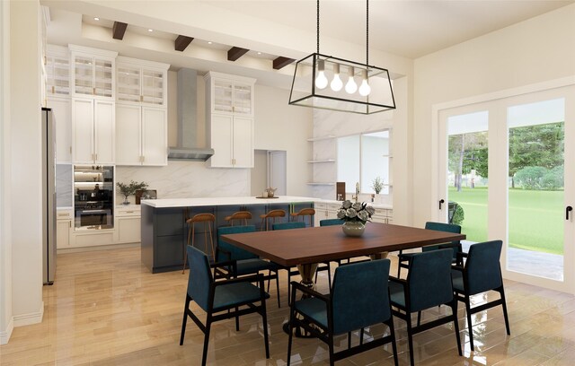 dining area featuring beam ceiling and light hardwood / wood-style flooring