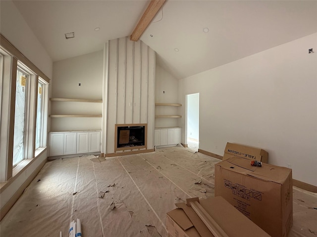 unfurnished living room featuring a fireplace and lofted ceiling with beams