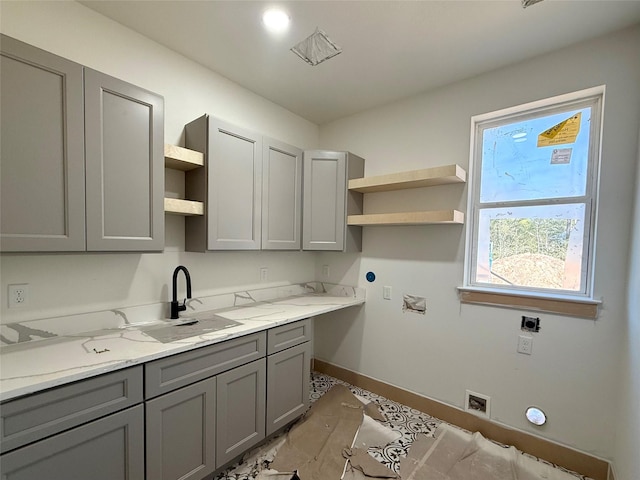 clothes washing area with cabinets, sink, and hookup for an electric dryer