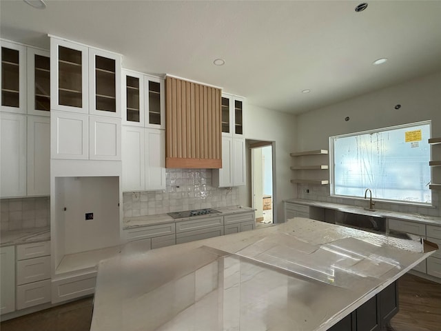 kitchen with white cabinetry, light stone countertops, and a center island