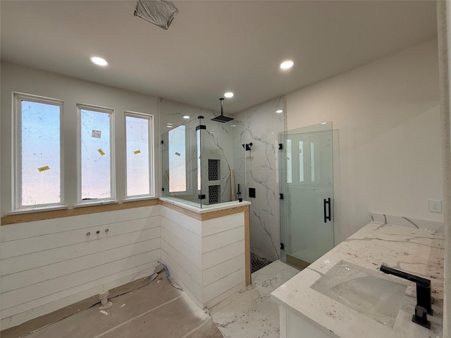 bathroom with a shower with door and vanity