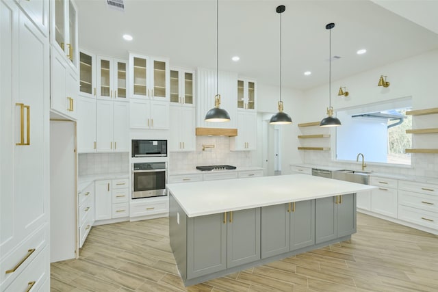 kitchen featuring open shelves, stainless steel appliances, gray cabinetry, and light countertops