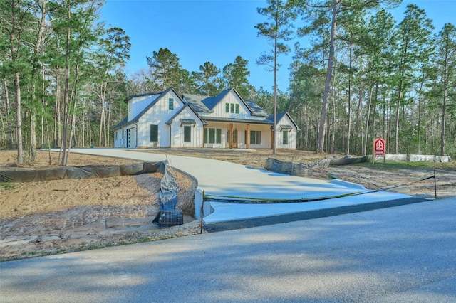 view of front facade featuring concrete driveway and board and batten siding