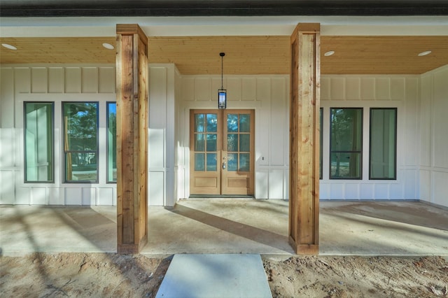 entrance to property with french doors, covered porch, and board and batten siding