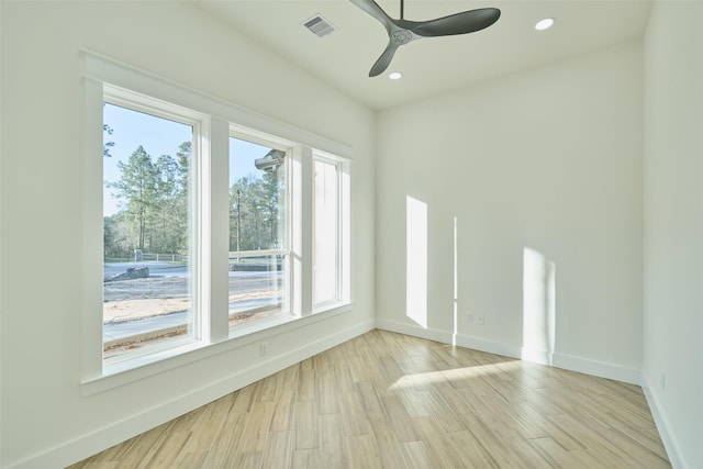 spare room with light wood-style floors, visible vents, and baseboards