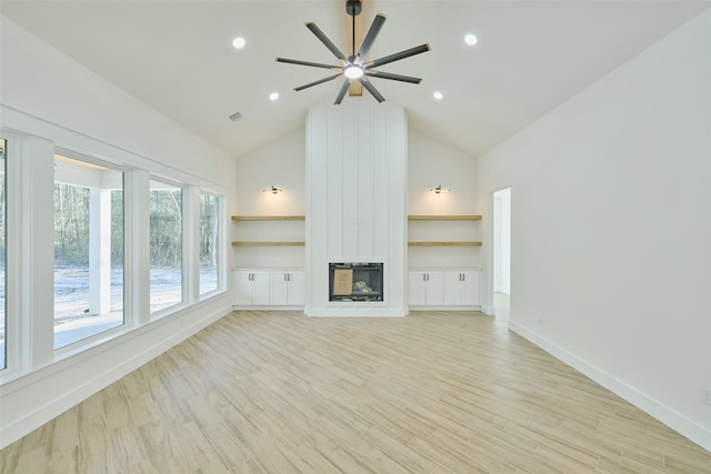 unfurnished living room with light wood finished floors, a large fireplace, baseboards, recessed lighting, and high vaulted ceiling