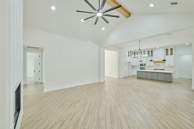 unfurnished living room featuring light wood finished floors, visible vents, beamed ceiling, ceiling fan with notable chandelier, and high vaulted ceiling