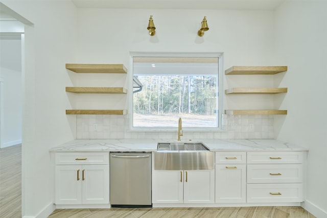 kitchen featuring white cabinetry, open shelves, a sink, decorative backsplash, and stainless steel dishwasher