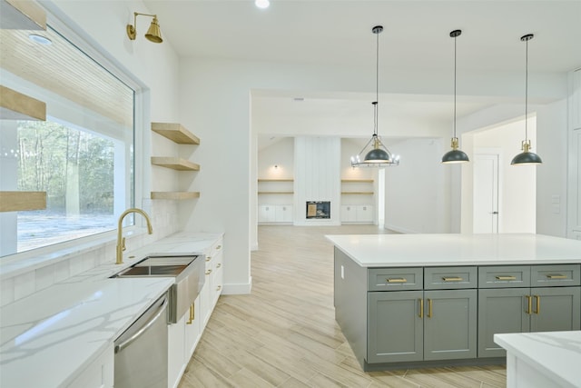 kitchen with light wood finished floors, open shelves, pendant lighting, and stainless steel dishwasher