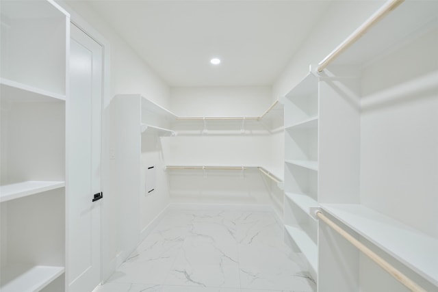 walk in closet featuring marble finish floor