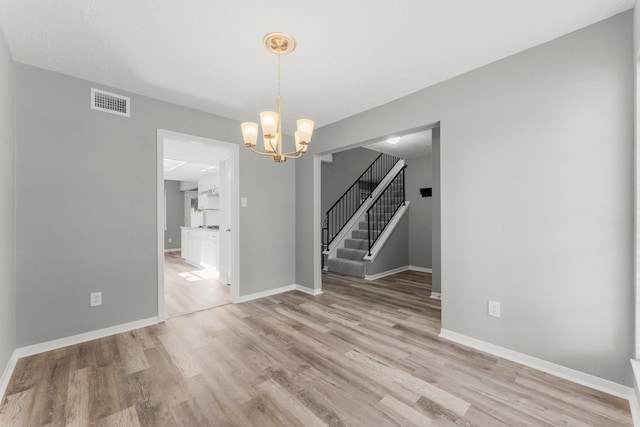 unfurnished dining area featuring a chandelier and light hardwood / wood-style floors