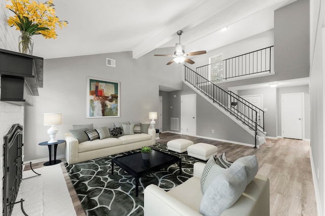 living room featuring beam ceiling, light hardwood / wood-style flooring, high vaulted ceiling, and ceiling fan