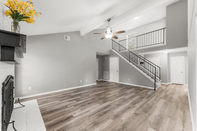 unfurnished living room featuring hardwood / wood-style floors, beamed ceiling, high vaulted ceiling, and ceiling fan