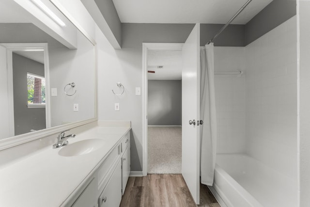 bathroom featuring vanity, hardwood / wood-style floors, and shower / tub combo with curtain