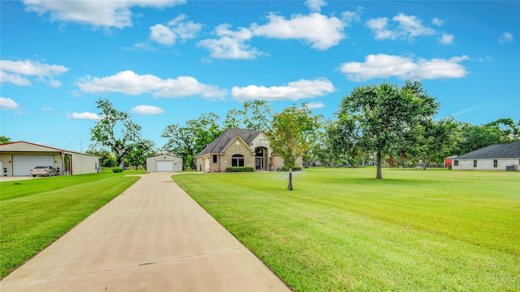 view of front of property featuring a garage, an outbuilding, and a front yard