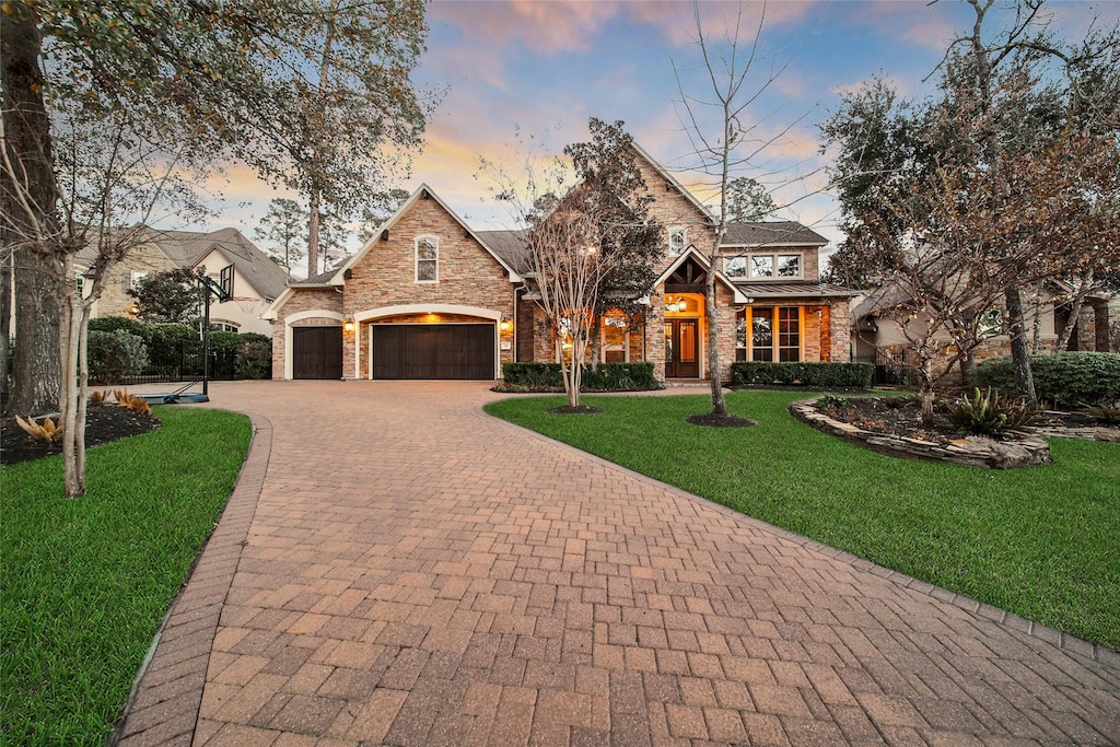 english style home featuring a garage and a lawn