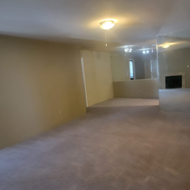 carpeted empty room with a fireplace