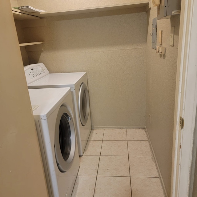 laundry area with washer and clothes dryer and light tile patterned floors