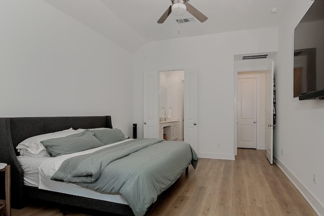 bedroom featuring lofted ceiling, light wood-type flooring, connected bathroom, and ceiling fan