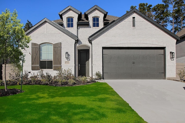 french country home with a garage and a front yard