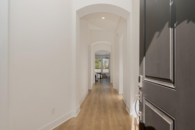 hallway with light hardwood / wood-style floors