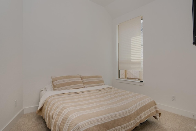 carpeted bedroom with lofted ceiling