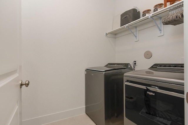 washroom with washer and clothes dryer and light tile patterned flooring