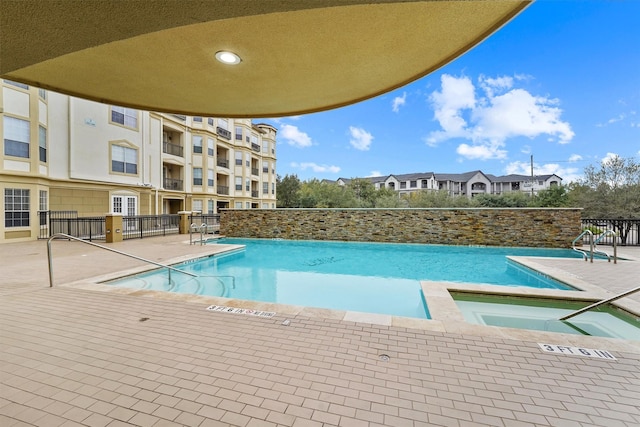 view of pool featuring a hot tub and a patio area