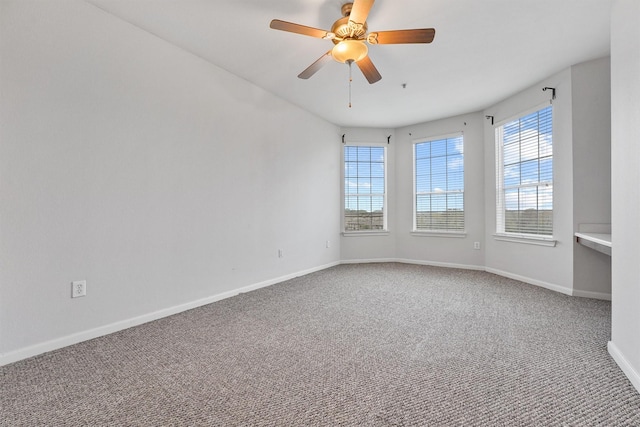 spare room with ceiling fan and carpet