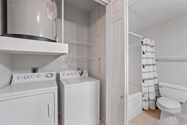 washroom with water heater, washer and dryer, and light tile patterned floors