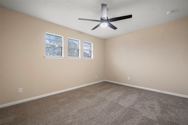 carpeted empty room with ceiling fan and a textured ceiling