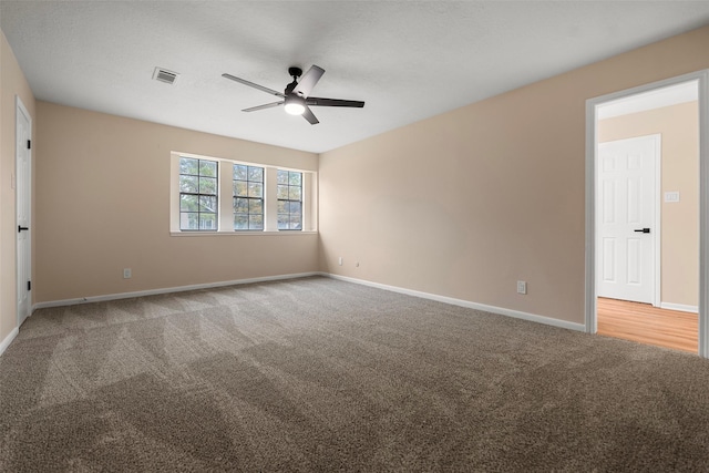 empty room featuring ceiling fan and carpet