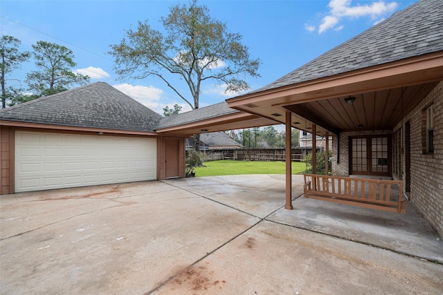 view of patio with french doors, a garage, and an outdoor structure