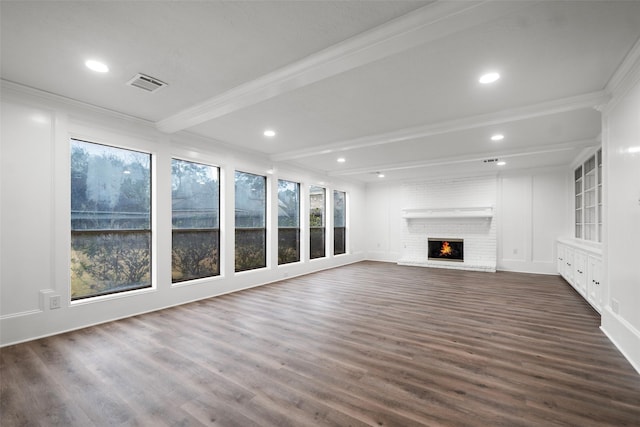 unfurnished living room featuring beamed ceiling, ornamental molding, dark hardwood / wood-style flooring, and a brick fireplace