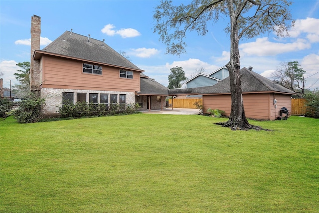 rear view of house with a yard and a patio area