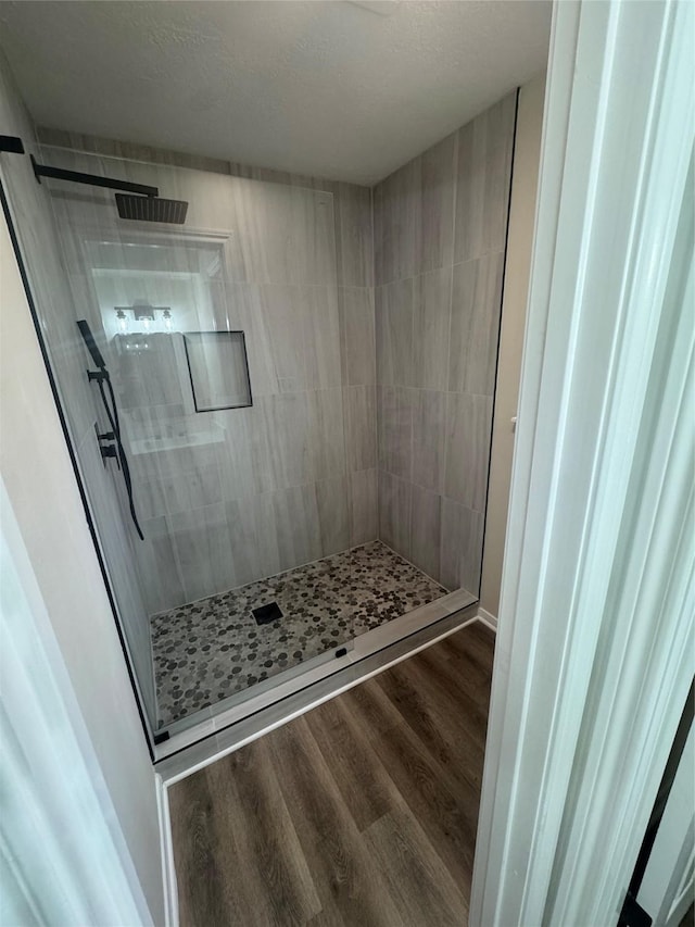 bathroom featuring hardwood / wood-style flooring and tiled shower