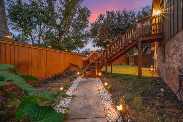 yard at dusk featuring a deck