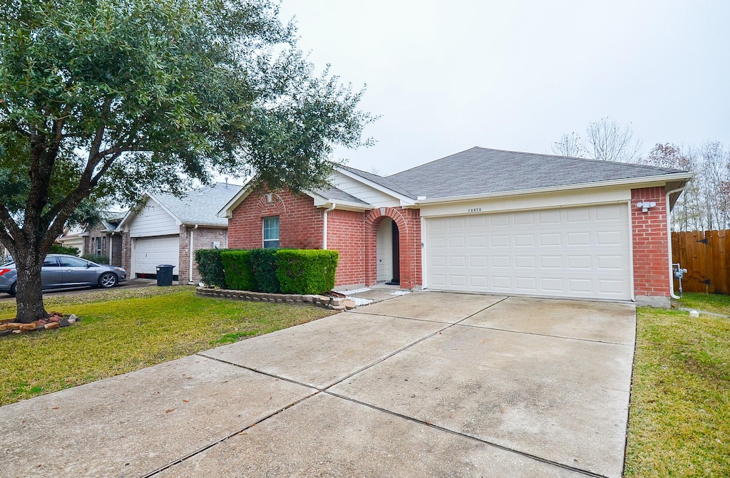 ranch-style house featuring a garage and a front yard