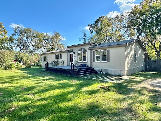 view of front facade with a deck, a front lawn, and fence