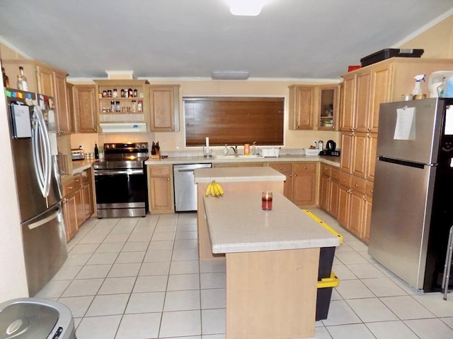 kitchen with a center island, under cabinet range hood, light countertops, appliances with stainless steel finishes, and light tile patterned flooring