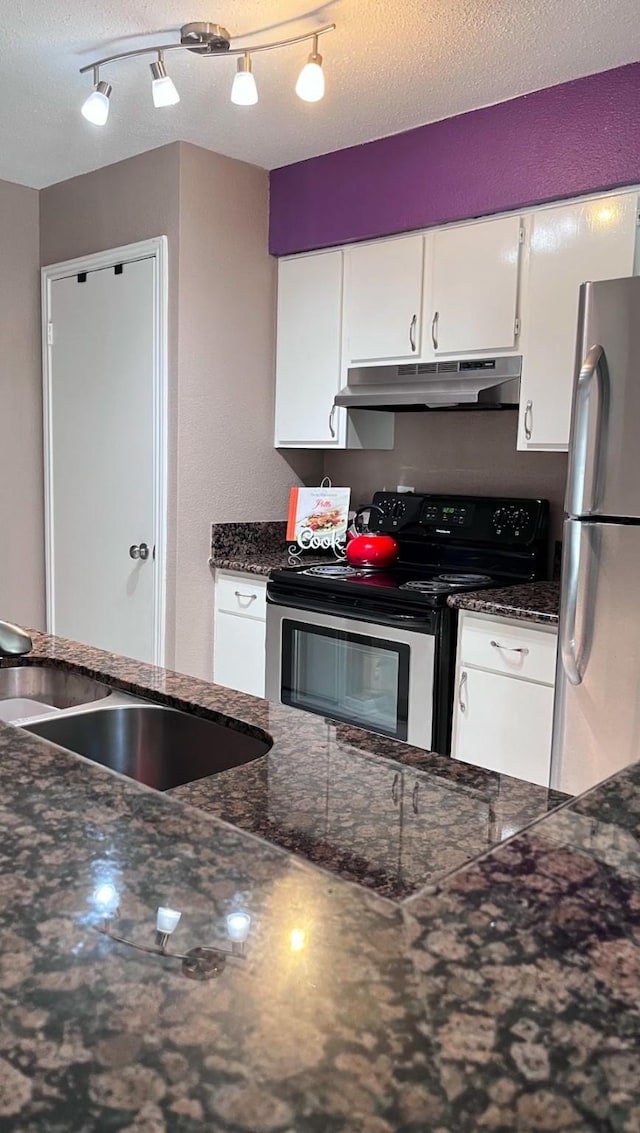 kitchen featuring sink, white cabinetry, a textured ceiling, dark stone countertops, and stainless steel appliances