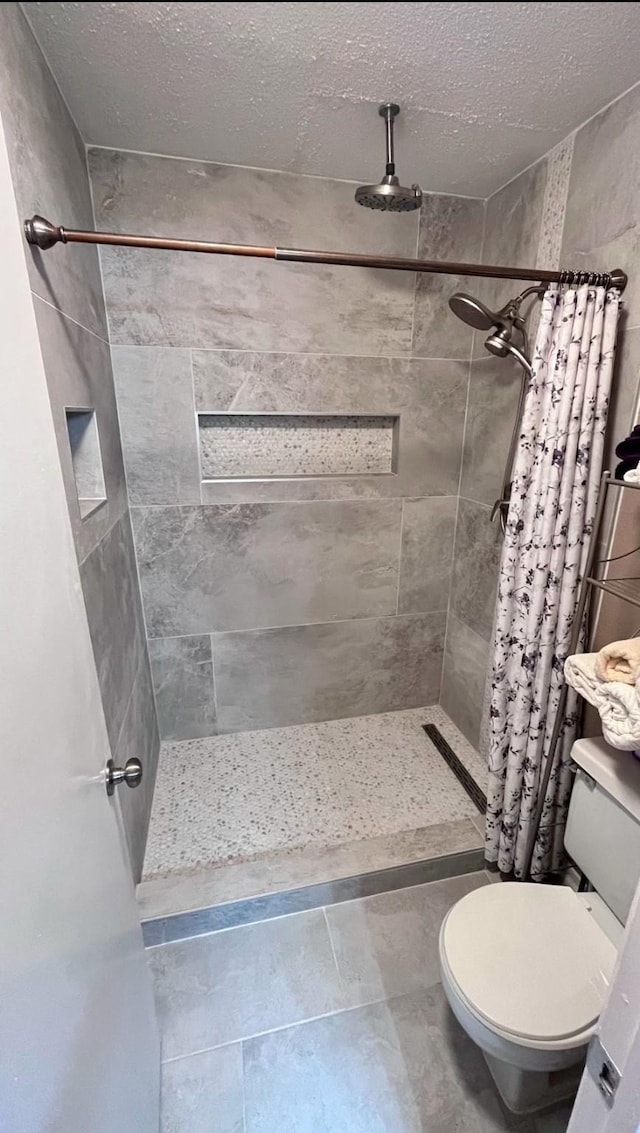 bathroom featuring walk in shower, toilet, and a textured ceiling