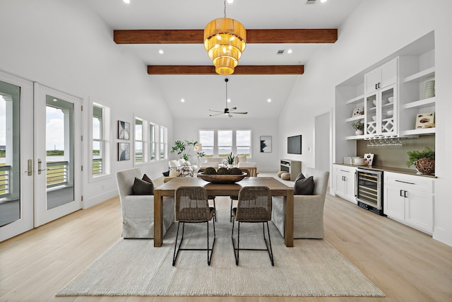 dining space featuring light hardwood / wood-style flooring, high vaulted ceiling, bar area, beverage cooler, and beamed ceiling