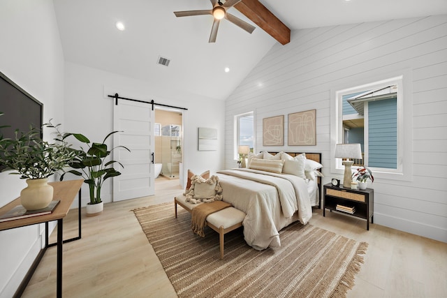 bedroom with beam ceiling, ensuite bath, high vaulted ceiling, ceiling fan, and a barn door