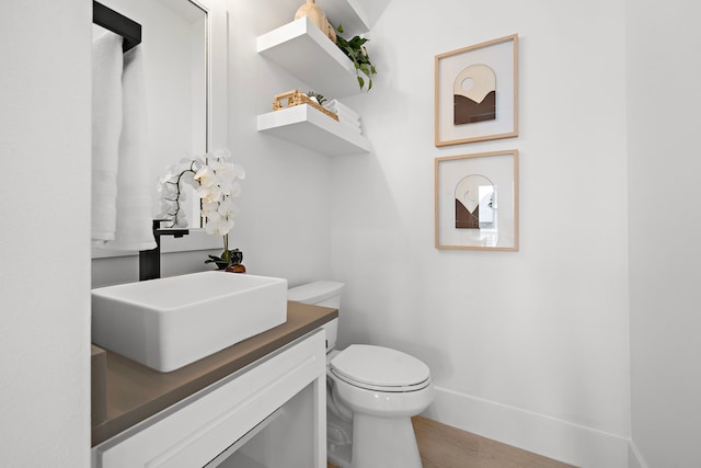 bathroom with vanity, hardwood / wood-style flooring, and toilet